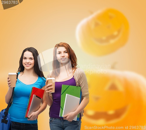 Image of smiling student girls with books and paper cups