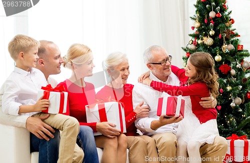 Image of smiling family with gifts at home