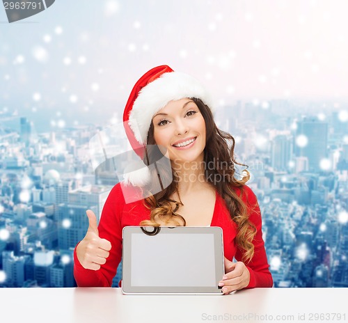 Image of smiling woman in santa hat with gift and tablet pc