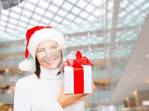 Image of smiling woman in santa helper hat with gift box
