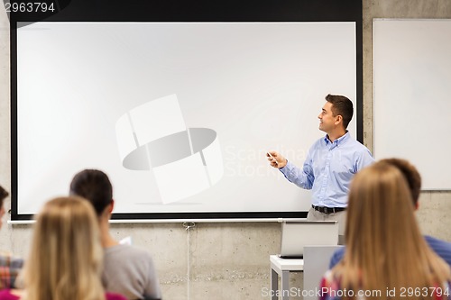 Image of group of students and smiling teacher in classroom