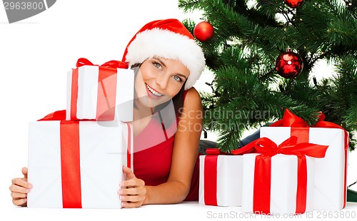 Image of smiling woman in santa helper hat with gift boxes