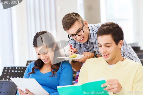 Image of group of smiling students with notebooks