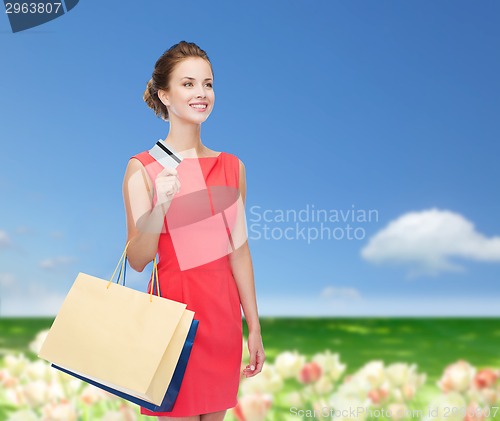 Image of smiling woman with shopping bags and plastic card