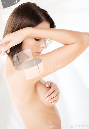 Image of woman checking breast for signs of cancer