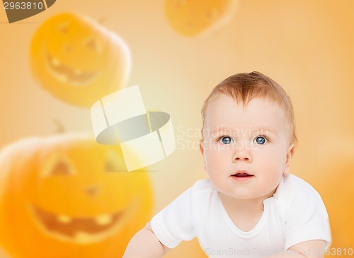 Image of smiling baby over pumpkins background