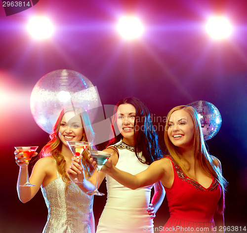 Image of three smiling women with cocktails and disco ball