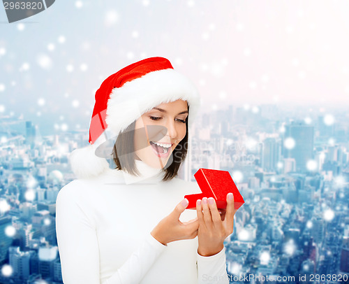 Image of smiling woman in santa helper hat with gift box