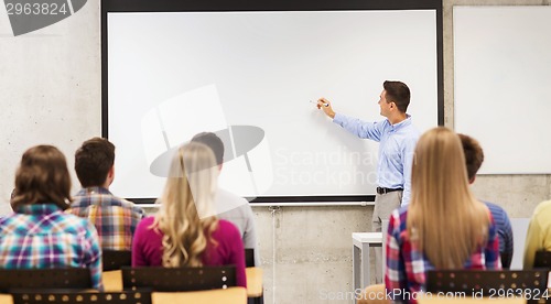 Image of group of students and smiling teacher in classroom