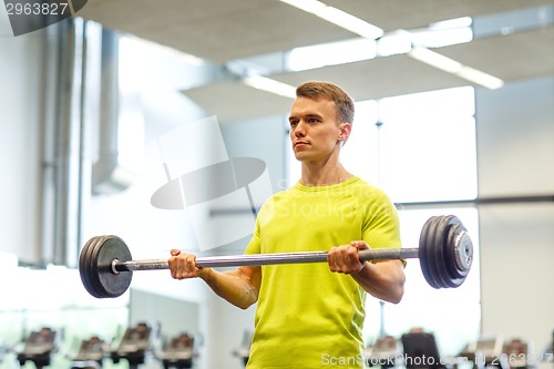 Image of man doing exercise with barbell in gym