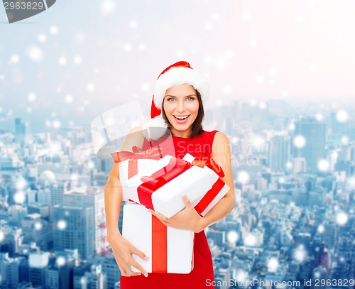Image of smiling woman in santa helper hat with gift boxes