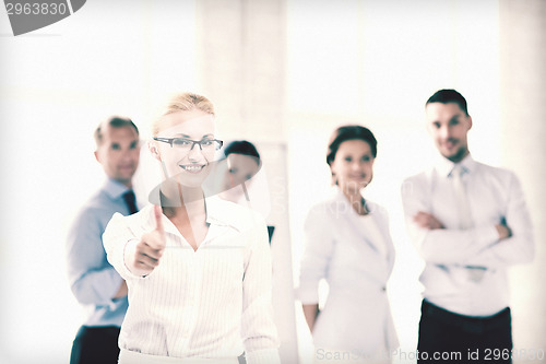 Image of businesswoman in office showign thumbs up