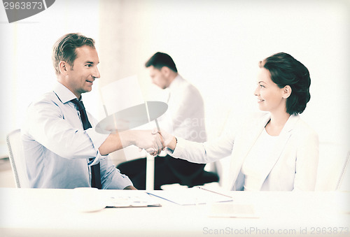 Image of man and woman shaking hands in office