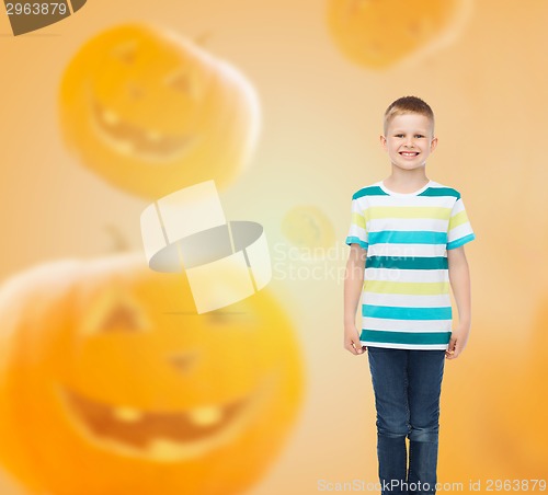 Image of smiling boy over pumpkins background