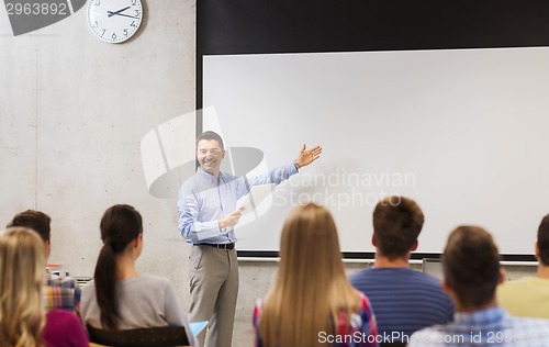 Image of group of students and smiling teacher with notepad