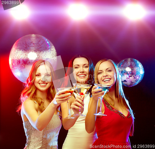 Image of three smiling women with cocktails and disco ball