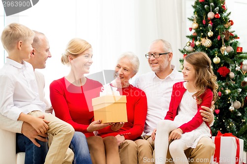 Image of smiling family with gifts at home