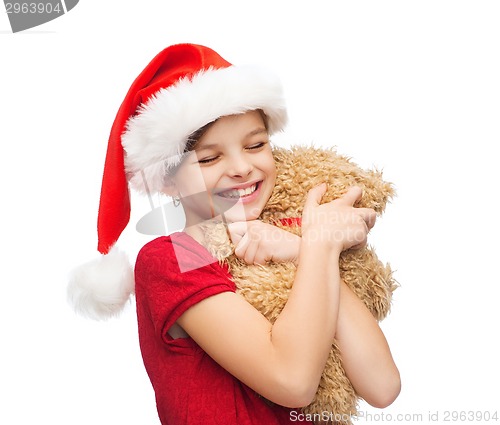 Image of smiling girl in santa helper hat with teddy bear