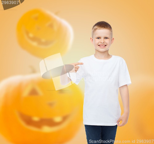 Image of smiling boy over pumpkins background