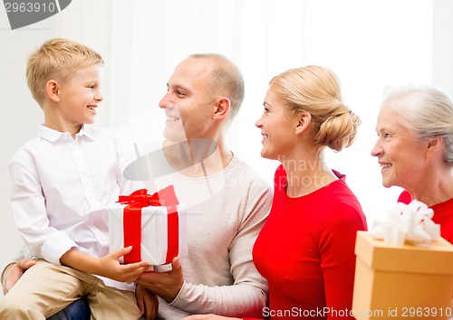 Image of smiling family with gifts at home