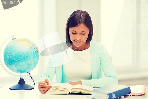 Image of teacher with globe and book at school