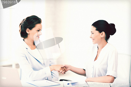 Image of businesswomen shaking hands in office