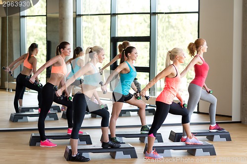 Image of group of women with dumbbells and steppers