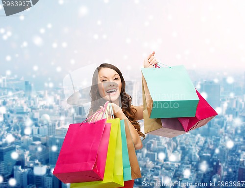 Image of smiling woman with colorful shopping bags