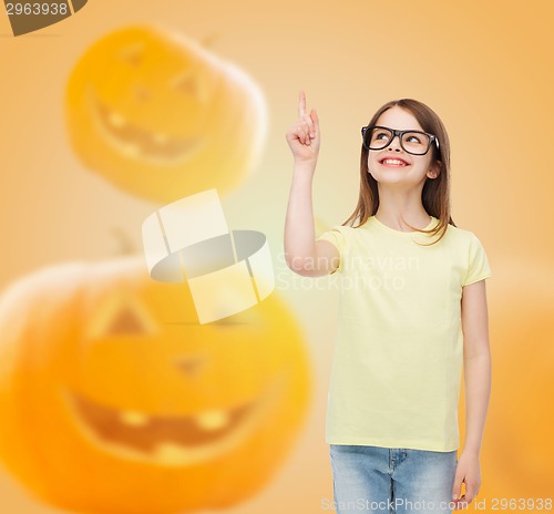 Image of smiling girl in glasses over pumpkins background