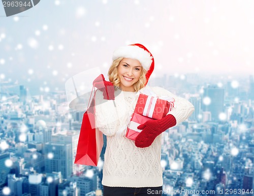 Image of smiling young woman in santa helper hat with gifts