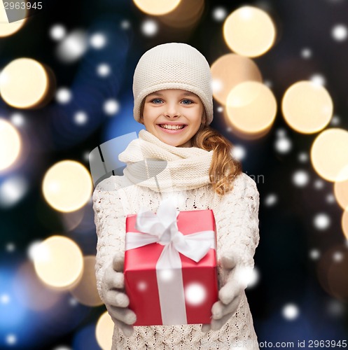 Image of girl in hat, muffler and gloves with gift box