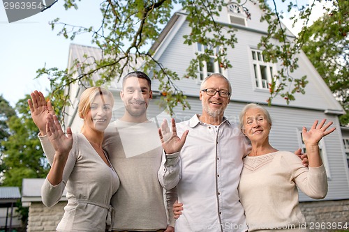 Image of happy family in front of house outdoors