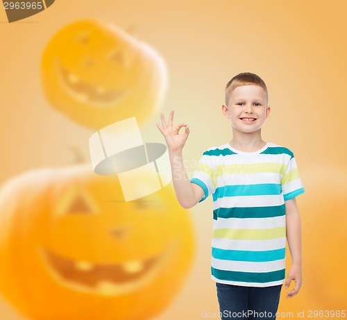 Image of smiling boy over pumpkins background