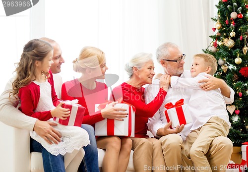 Image of smiling family with gifts at home