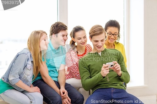 Image of smiling students with digital camera at school