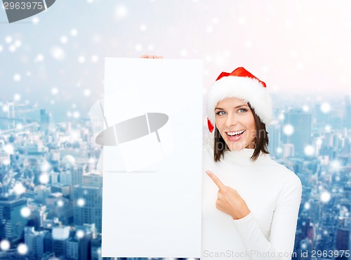 Image of smiling young woman in santa hat with white board