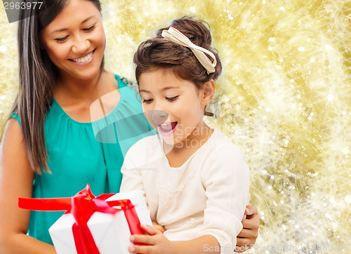 Image of happy mother and little girl with gift box