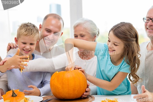 Image of happy family sitting with pumpkins at home