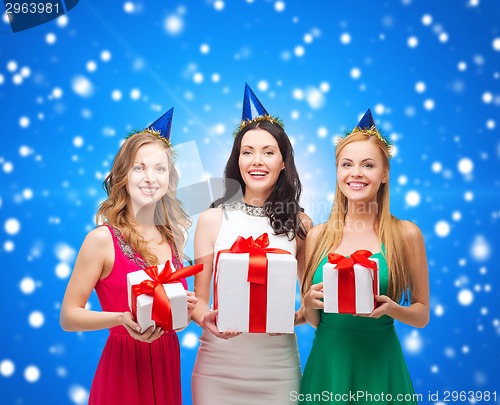 Image of smiling women in party caps with gift boxes