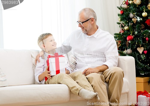 Image of smiling grandfather and grandson at home