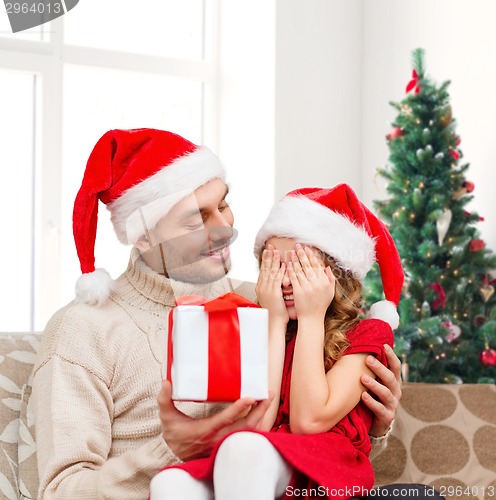 Image of smiling daughter waiting for present from father
