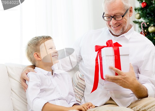 Image of smiling grandfather and grandson at home