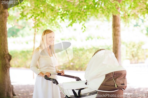 Image of happy mother with stroller in park