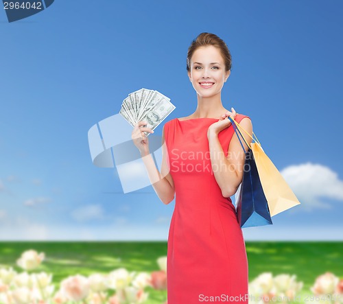 Image of smiling woman in red dress with shopping bags