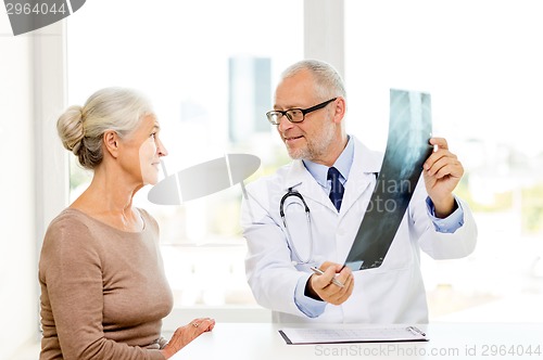 Image of smiling senior woman and doctor meeting