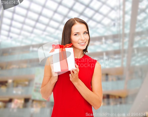 Image of smiling woman in red dress with gift box