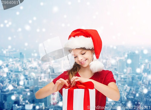 Image of smiling girl in santa helper hat with gift box