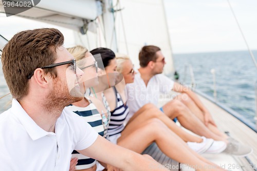 Image of smiling friends sitting on yacht deck