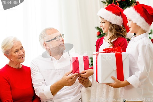 Image of smiling family with gifts at home