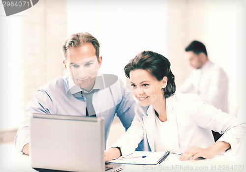 Image of man and woman working with laptop in office
